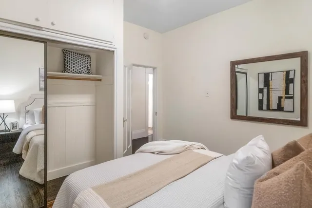 a bedroom with a bed and a mirror