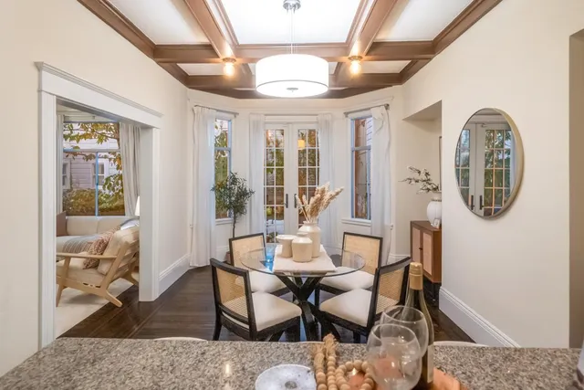 a dining room with furniture a chandelier and wooden floor