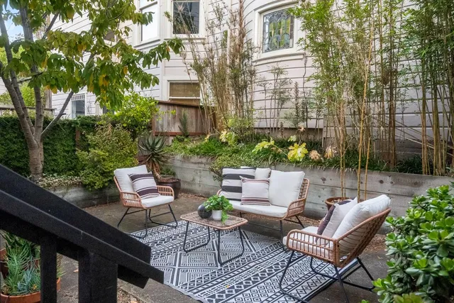 a view of a patio with couches table and chairs and potted plants