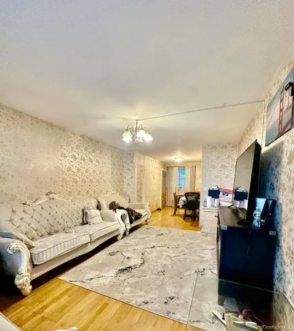 a living room with furniture and a dining table with wooden floor