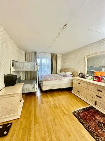 a bedroom with a bed and a view of living room