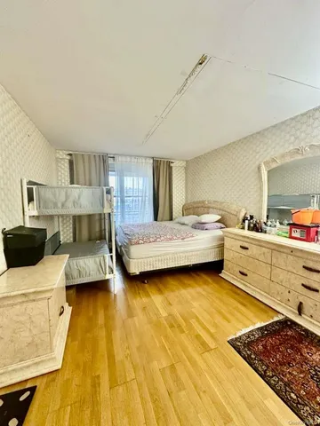 a bedroom with a bed and a view of living room