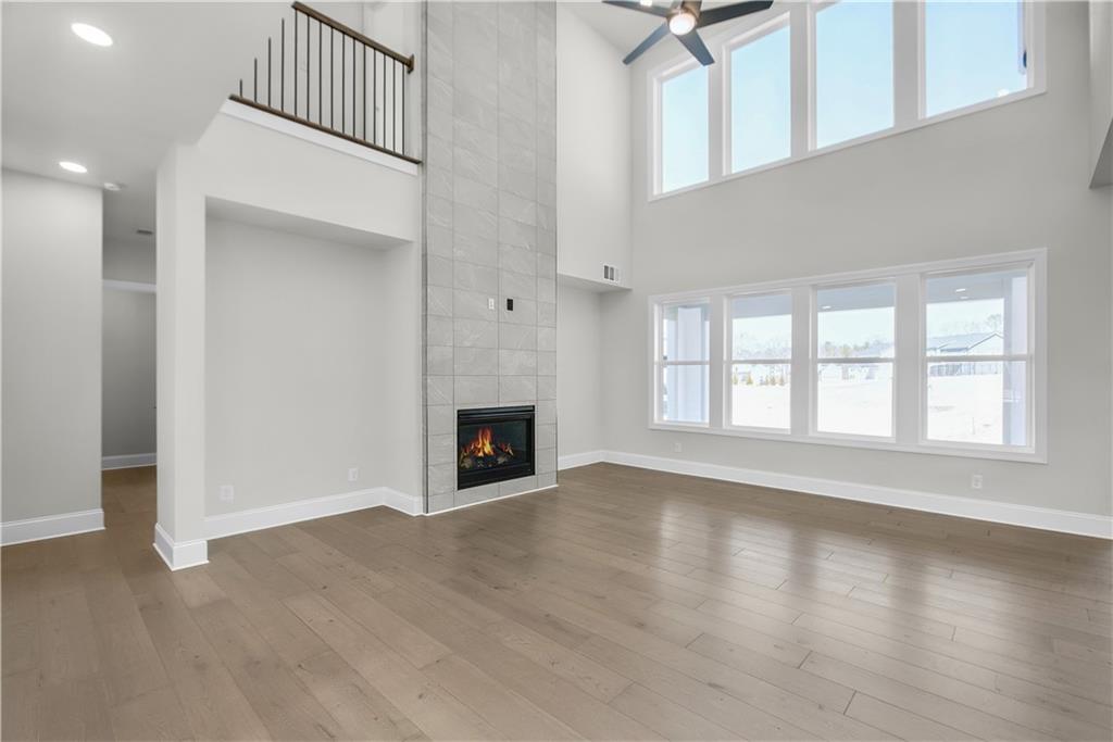 5005 Crestline View Road Cumming, GA 30028 - Photo 1 of 1 an empty room with wooden floor fireplace and windows