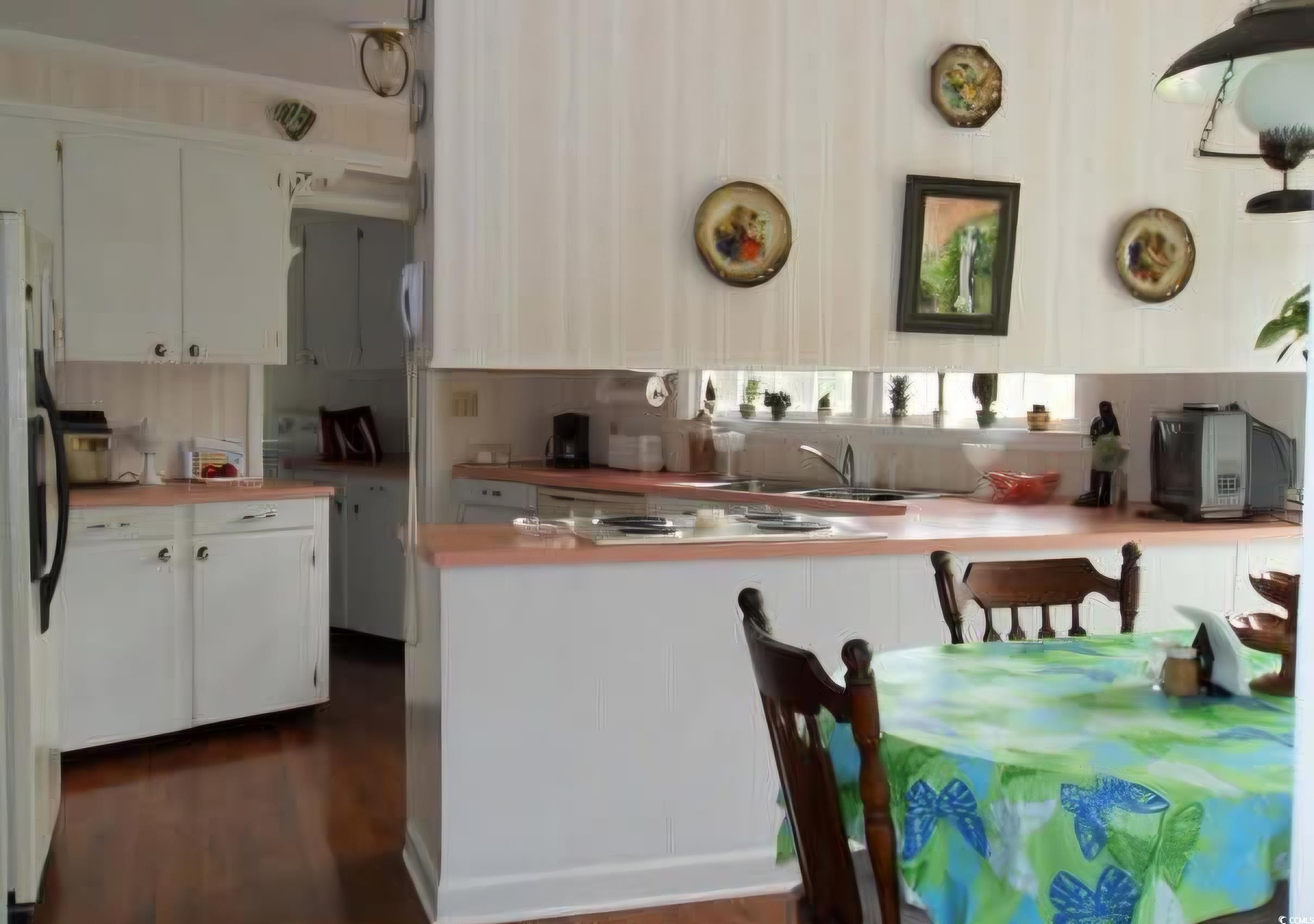 2840 Pennyroyal Road Georgetown, SC 29440 - Photo 28 of 36 Kitchen featuring white cabinets, a peninsula, light countertops, and freestanding refrigerator