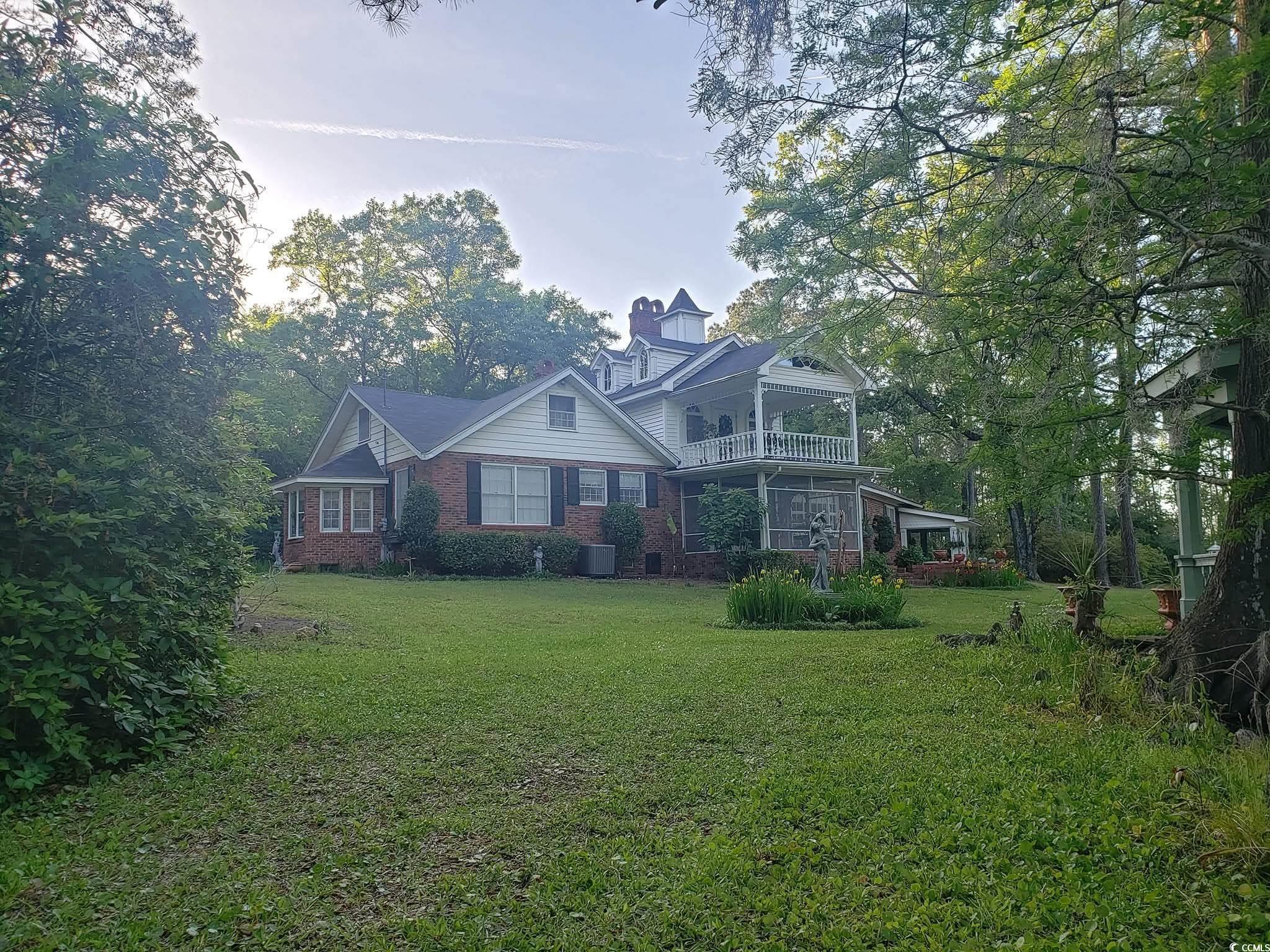 2840 Pennyroyal Road Georgetown, SC 29440 - Photo 3 of 36 View of back of property featuring a back lawn, a balcony, brick siding, and a chimney