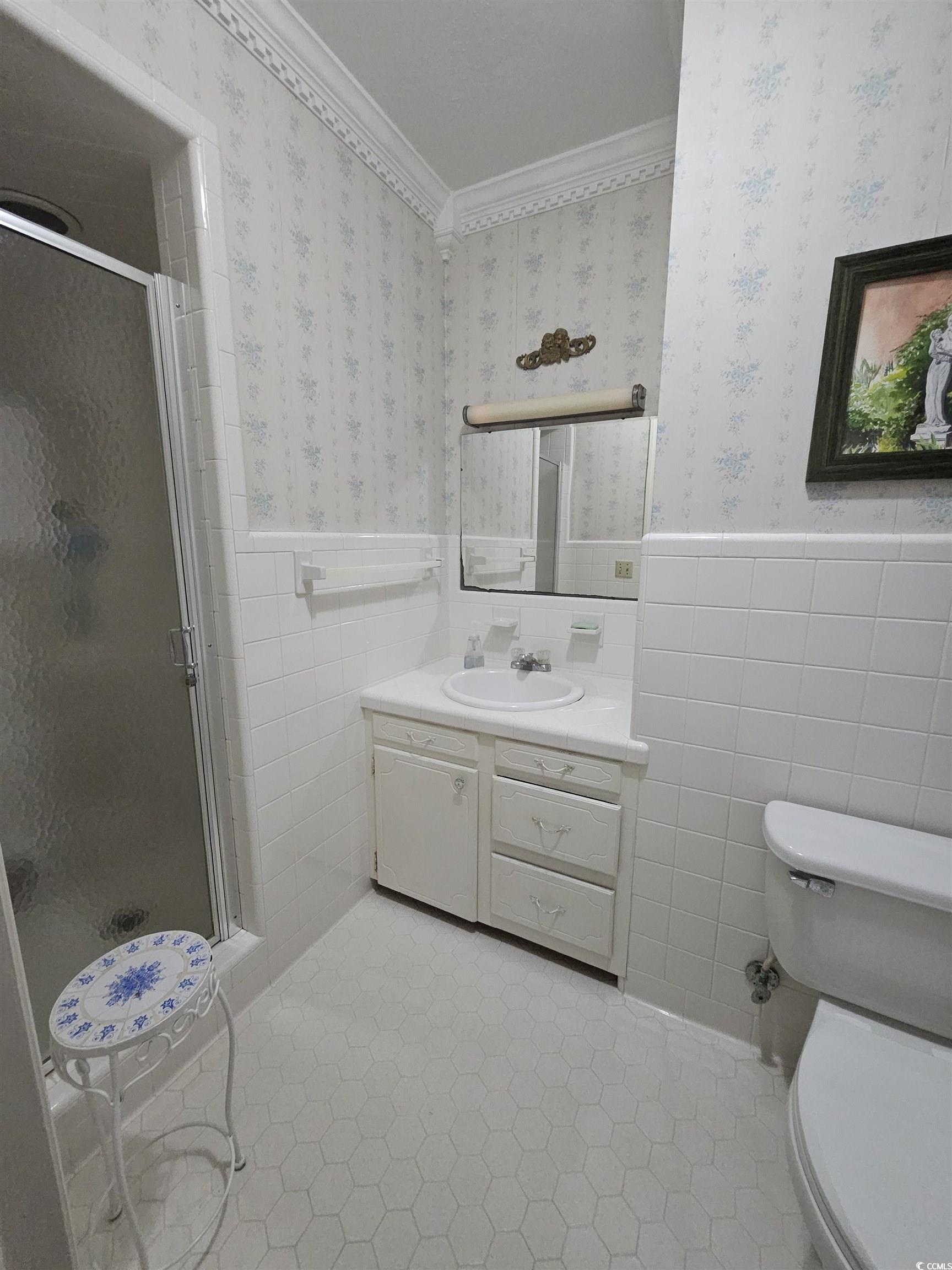 2840 Pennyroyal Road Georgetown, SC 29440 - Photo 31 of 36 Full bathroom with tile walls, vanity, a stall shower, wainscoting, and wallpapered walls