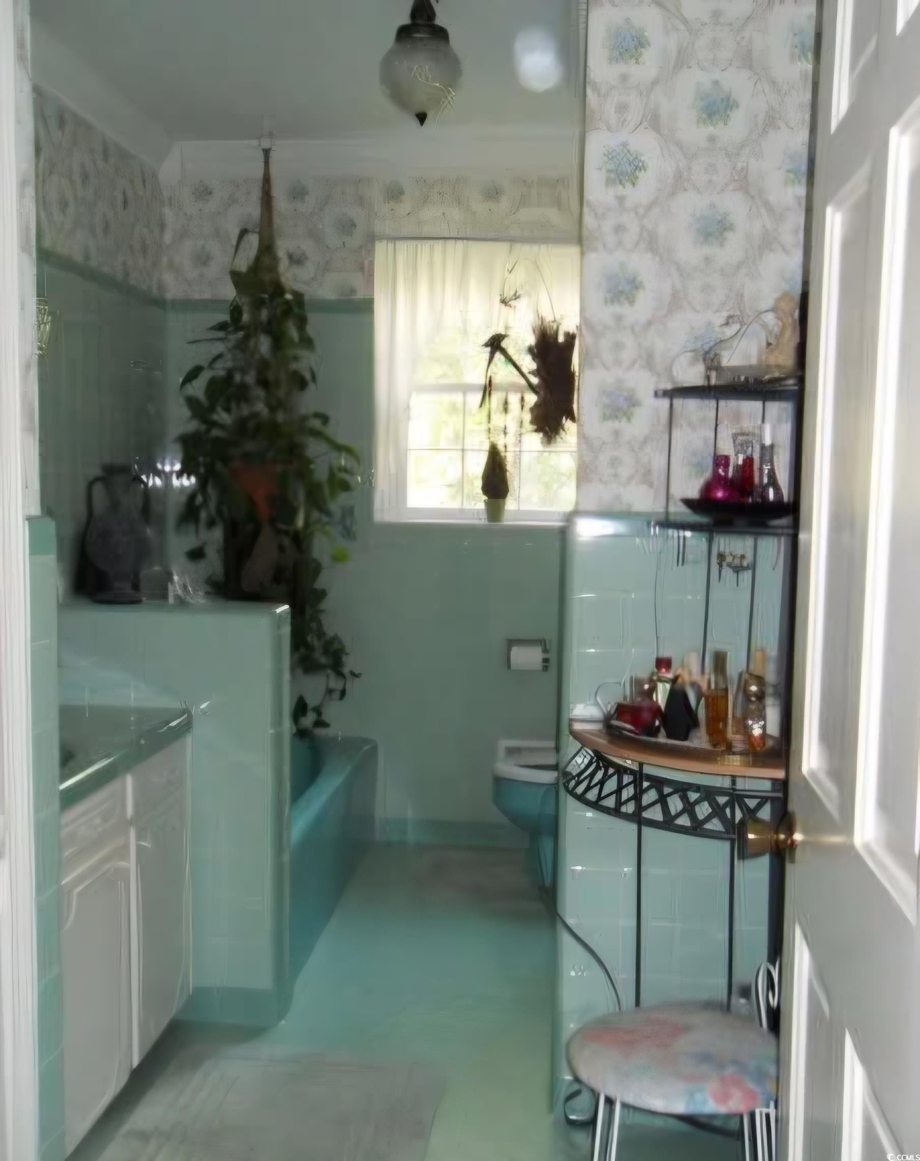 2840 Pennyroyal Road Georgetown, SC 29440 - Photo 32 of 36 Bathroom featuring a garden tub, wallpapered walls, vanity, and tile walls