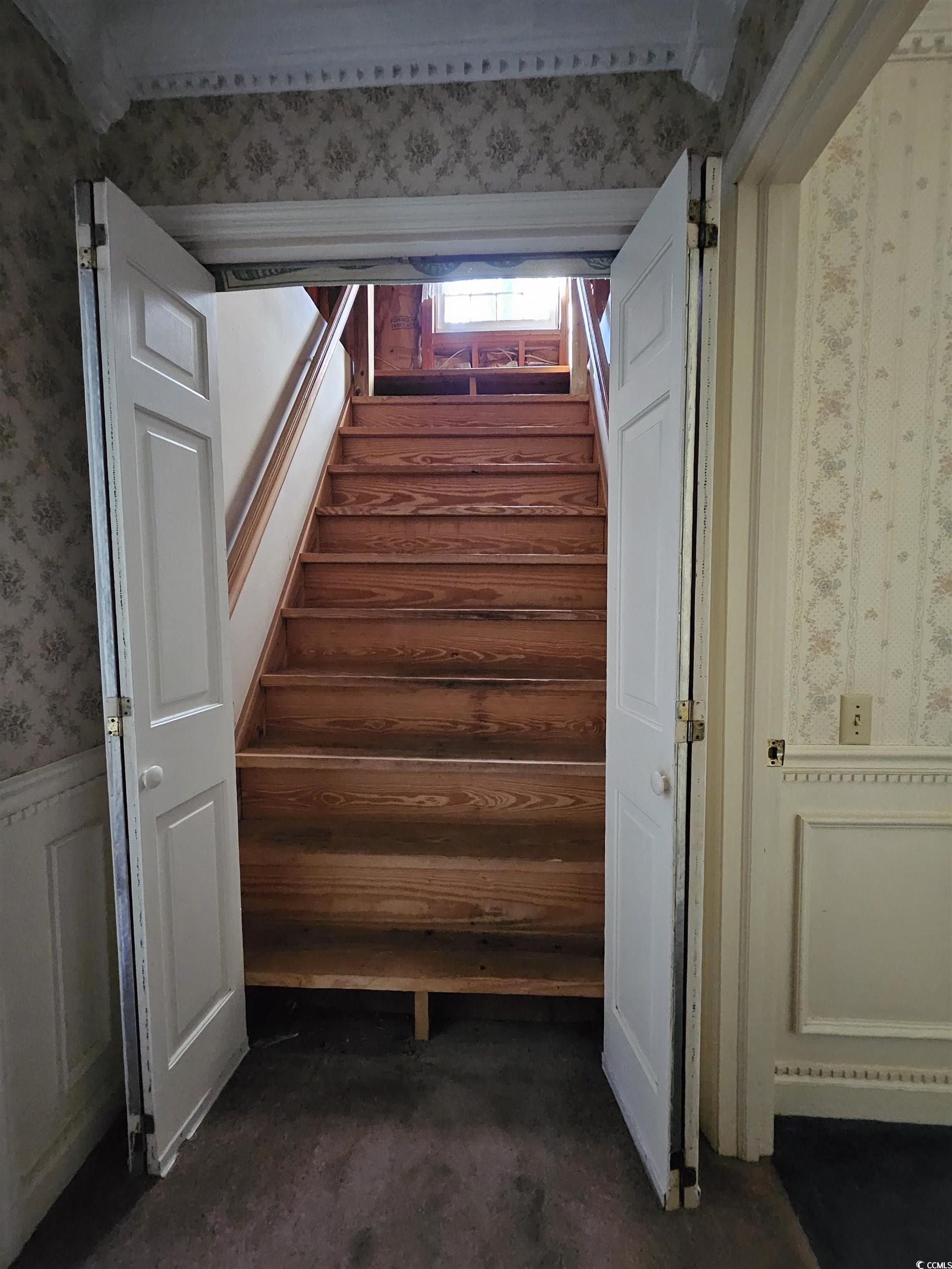 2840 Pennyroyal Road Georgetown, SC 29440 - Photo 33 of 36 Stairway with wallpapered walls, wainscoting, and a decorative wall