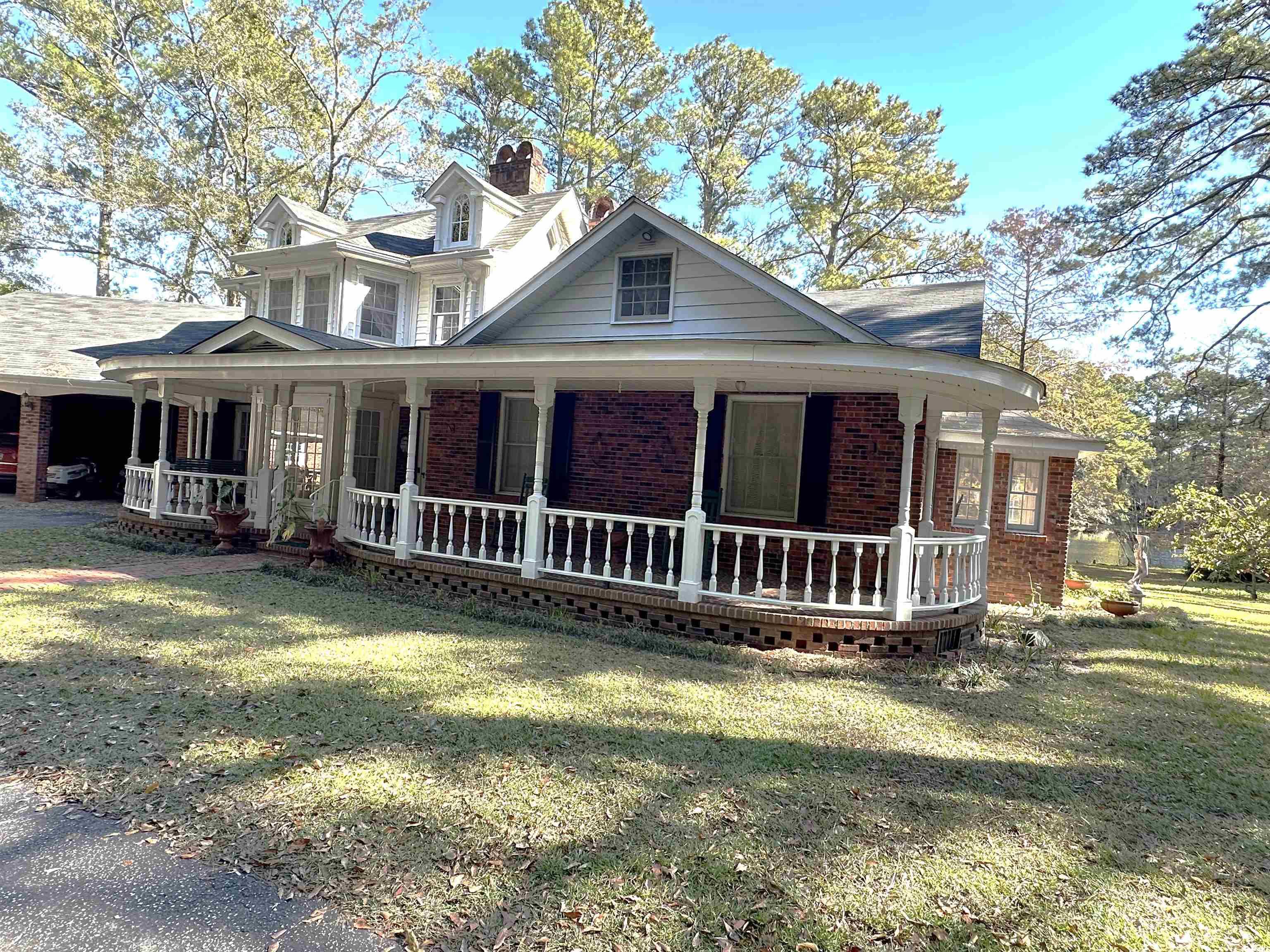 2840 Pennyroyal Road Georgetown, SC 29440 - Photo 9 of 36 View of front facade featuring covered porch, brick siding, a chimney, and a front lawn
