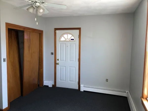 an empty room with windows and cabinet