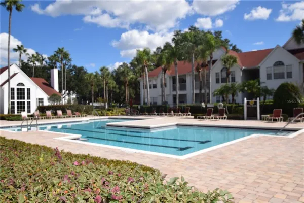 a view of a white house with a swimming pool and a bench