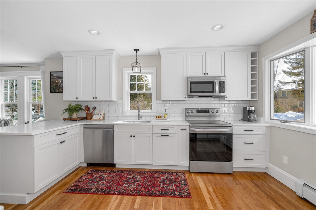 430 West Street Reading, MA 01867 - Photo 10 of 35 a kitchen with stainless steel appliances granite countertop a stove top oven a sink dishwasher and white cabinets with wooden floor