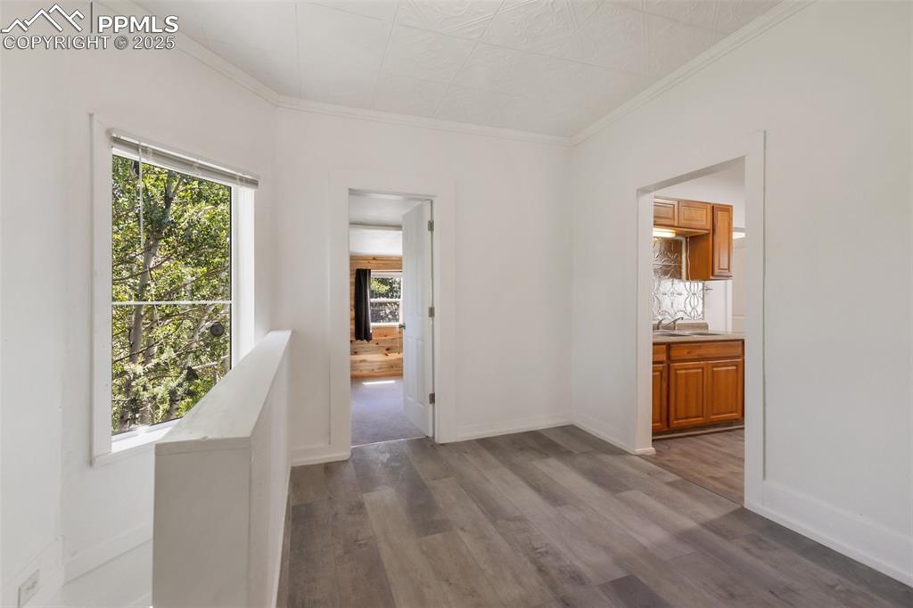 210 7th Street Victor, CO 80860 - Photo 14 of 38 an empty room with wooden floor and windows