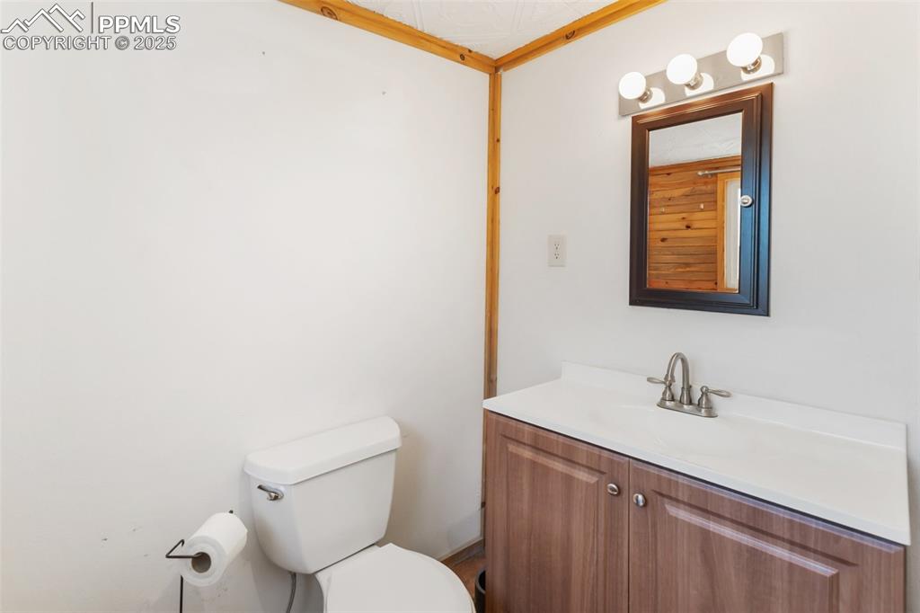 210 7th Street Victor, CO 80860 - Photo 25 of 38 a bathroom with a toilet a sink and mirror