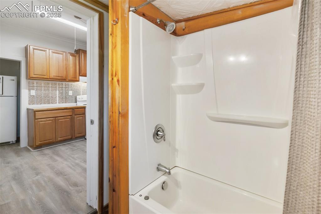 210 7th Street Victor, CO 80860 - Photo 26 of 38 a bathroom with a tub a sink and a large mirror