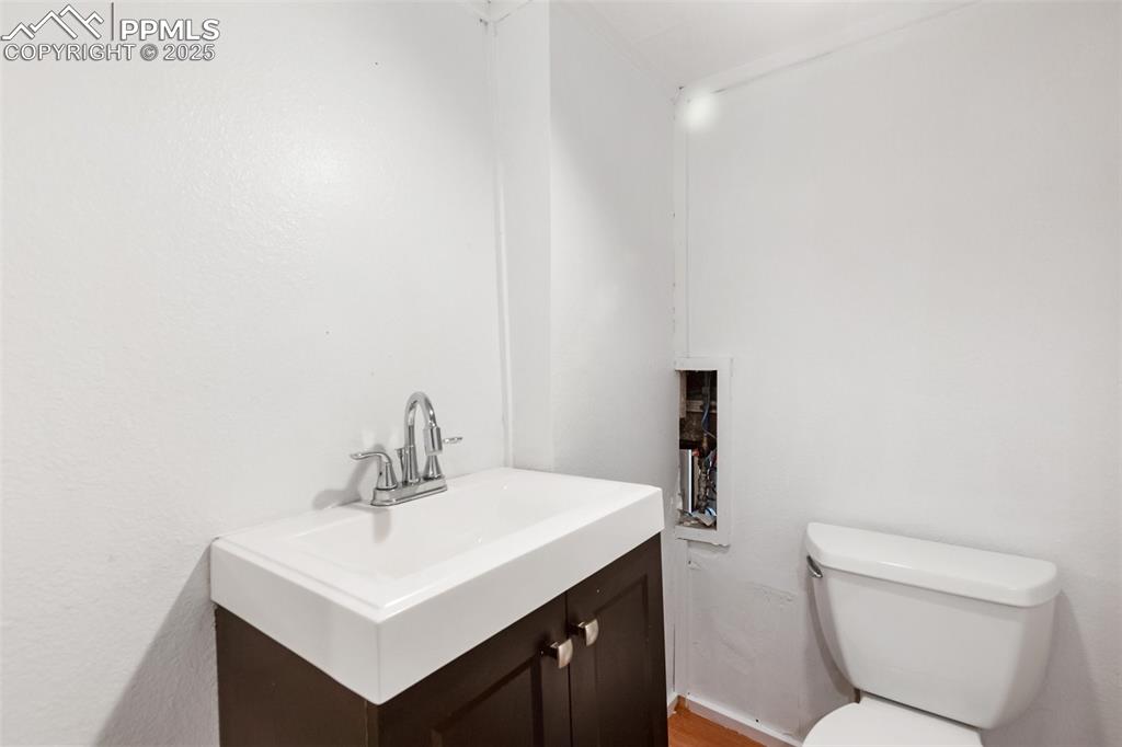 210 7th Street Victor, CO 80860 - Photo 34 of 38 a bathroom with a toilet a sink and mirror