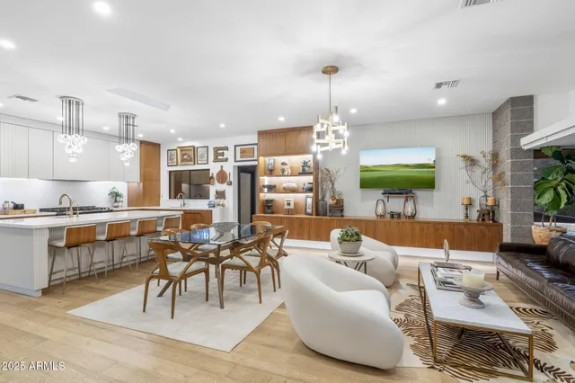 a living room with furniture kitchen view and a wooden floor