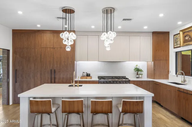 a kitchen with stainless steel appliances a table chairs and chandelier