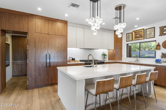 a kitchen with kitchen island granite countertop a sink a center island and stainless steel appliances