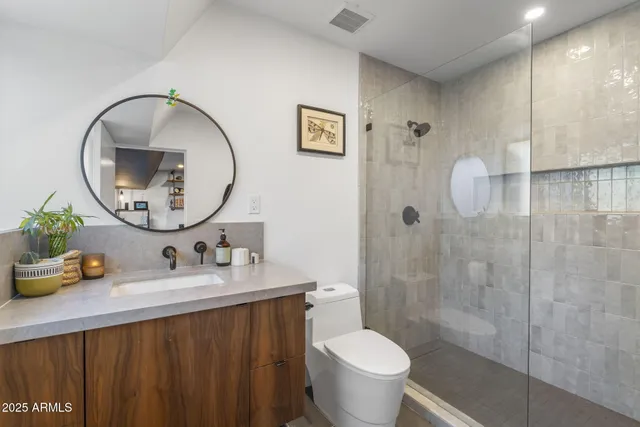 a bathroom with a sink a toilet and a mirror