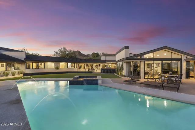 a view of a house with swimming pool and sitting area