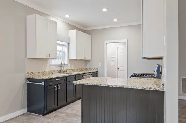 a kitchen with stainless steel appliances granite countertop a sink stove and cabinets