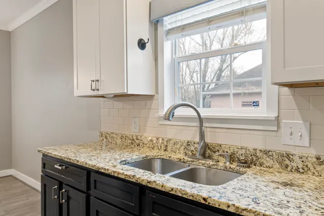 a kitchen with granite countertop a sink and a window