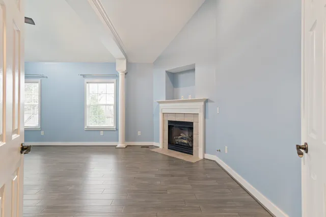 wooden floor fireplace and windows in an empty room