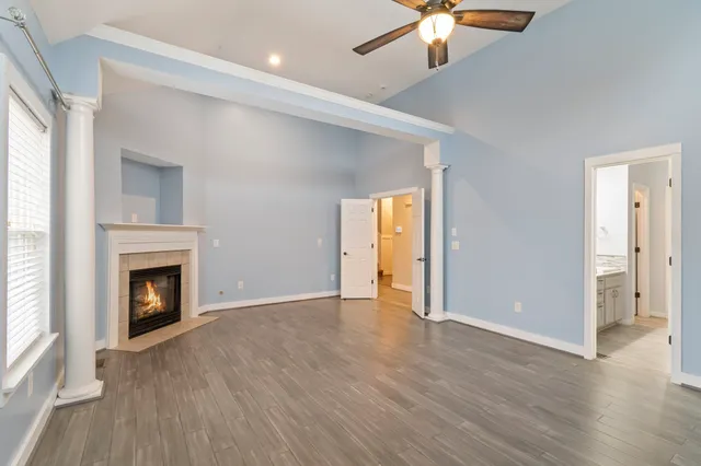 wooden floor fireplace and windows in an empty room