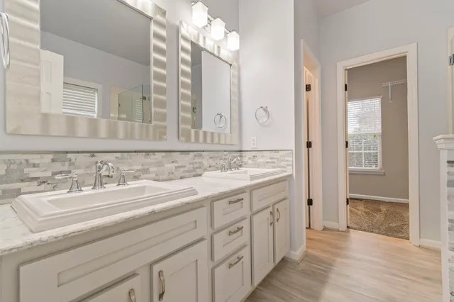a spacious bathroom with a double vanity sink and a mirror