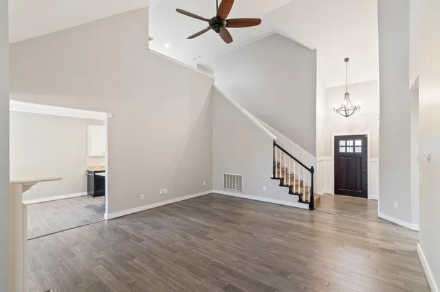 a view of a hallway with wooden floor and staircase