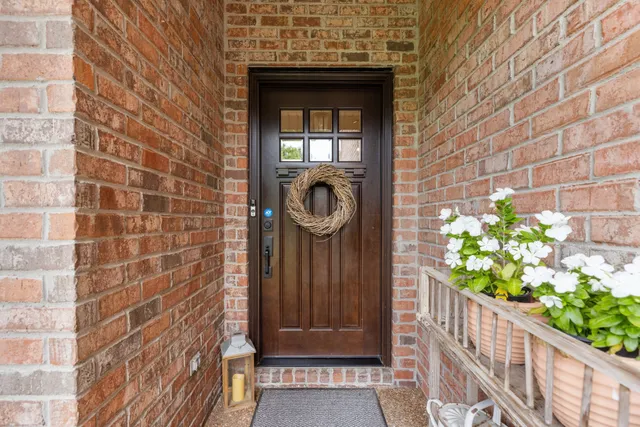 a view of a door of the house with a tree
