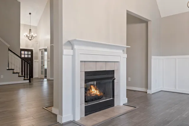 a living room with wooden floor and a fireplace