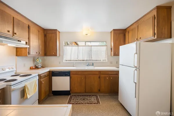 a kitchen with a sink a refrigerator and cabinets
