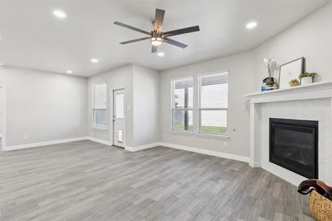 an empty room with windows and a fireplace