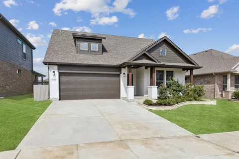 a front view of a house with a garden and yard