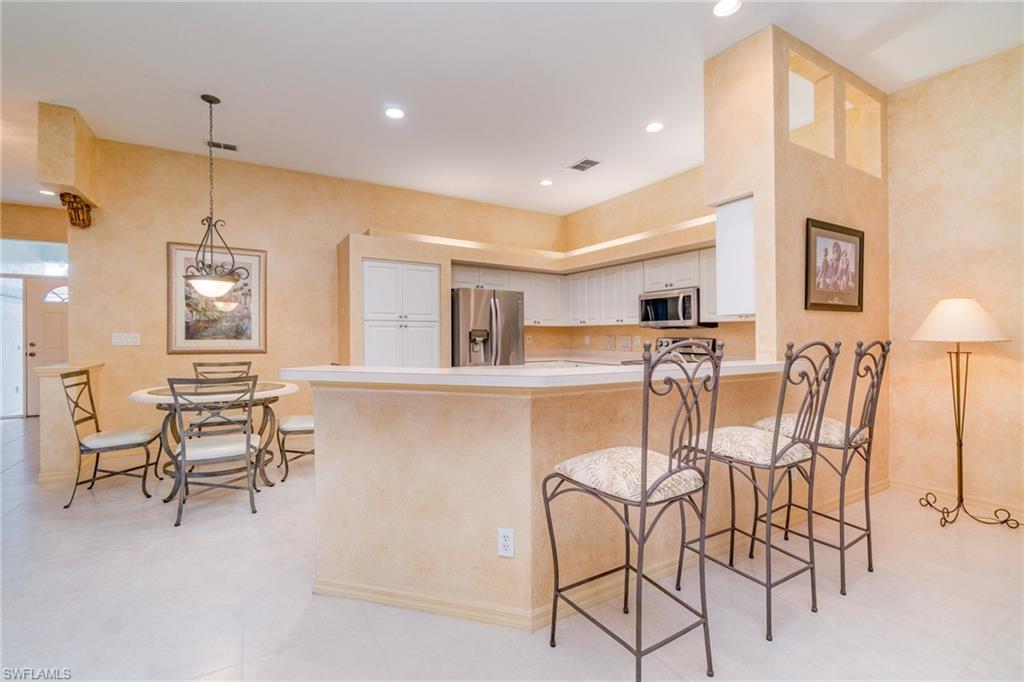 10274 Cape Roman Road, Unit 102 Estero, FL 34135 - Photo 12 of 36 a dining room with furniture and a table