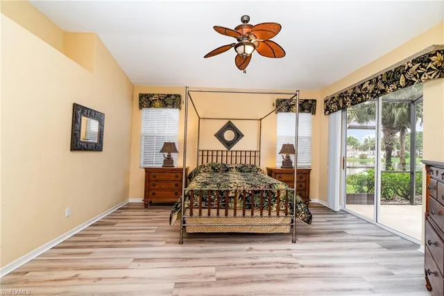 a view of a bedroom with wooden floor and a ceiling fan