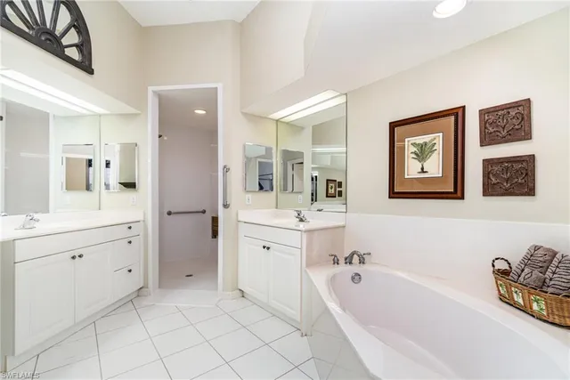 a spacious bathroom with a tub sink and mirror