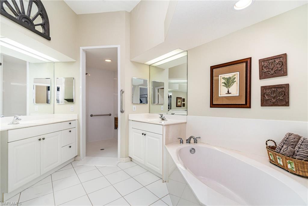 10274 Cape Roman Road, Unit 102 Estero, FL 34135 - Photo 15 of 36 a spacious bathroom with a tub sink and mirror
