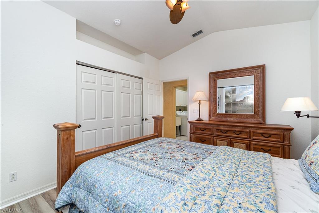 10274 Cape Roman Road, Unit 102 Estero, FL 34135 - Photo 17 of 36 a bedroom with a bed and wooden floor