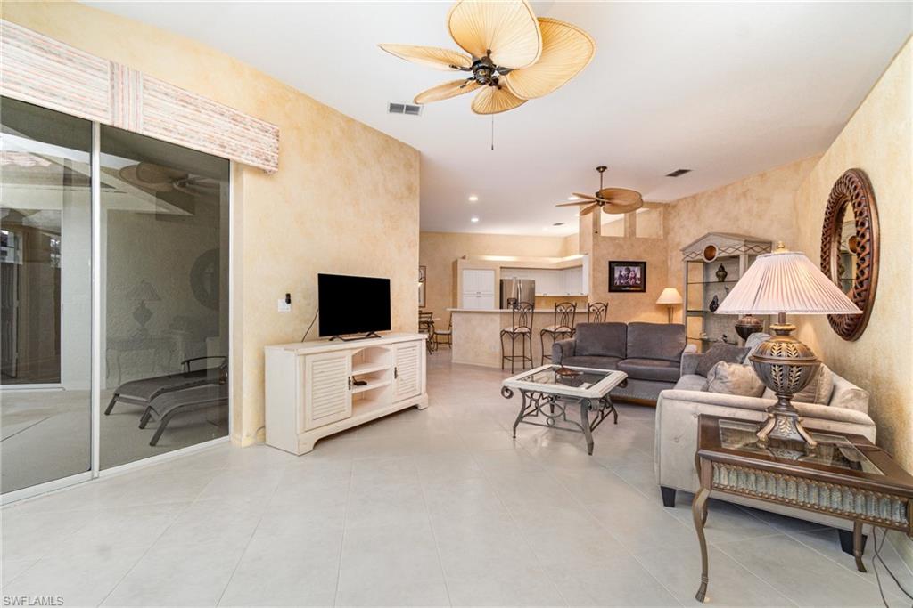 10274 Cape Roman Road, Unit 102 Estero, FL 34135 - Photo 4 of 36 a living room with furniture and a flat screen tv
