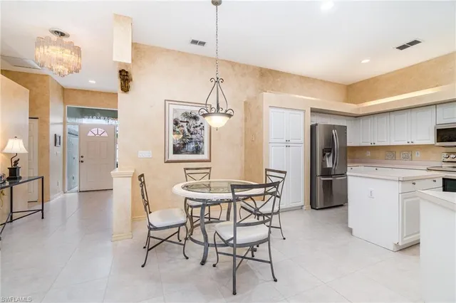 a kitchen with refrigerator a sink and chairs