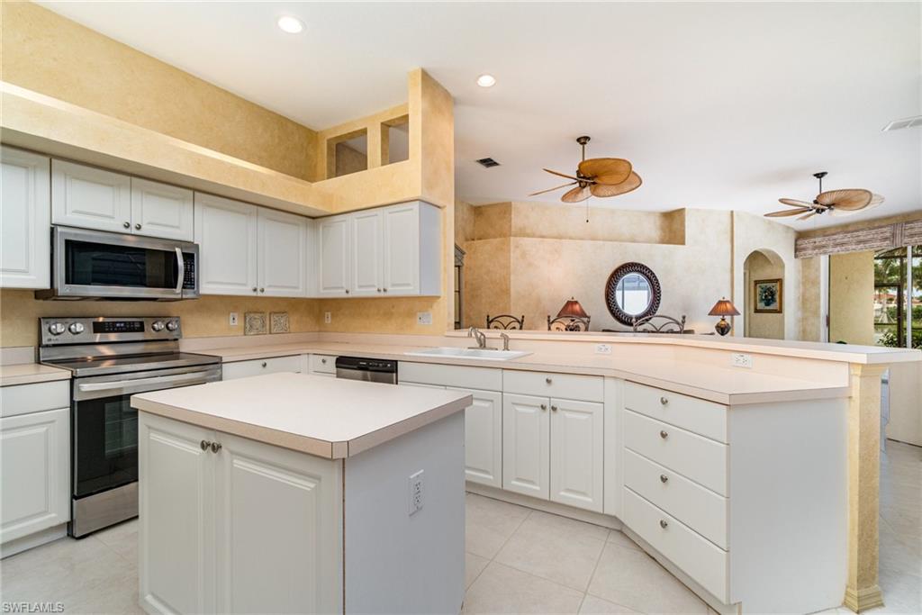 10274 Cape Roman Road, Unit 102 Estero, FL 34135 - Photo 8 of 36 a kitchen with a stove a sink and a microwave