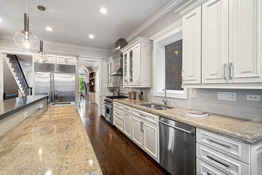 1904 West Wolfram Street Chicago, IL 60657 - Photo 18 of 56 a large kitchen with kitchen island a large counter space a sink stainless steel appliances and cabinets