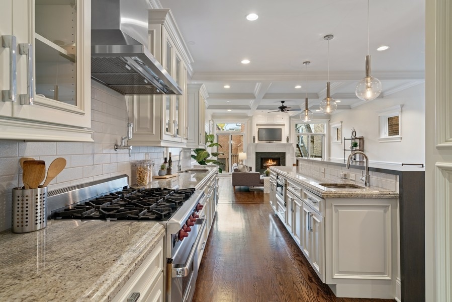 1904 West Wolfram Street Chicago, IL 60657 - Photo 19 of 56 a kitchen with stainless steel appliances a stove a sink a refrigerator and chairs