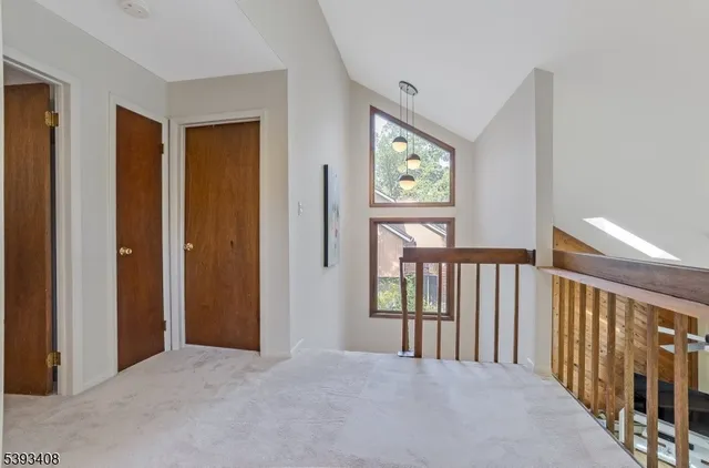 a view of a hallway to rooms and stairs