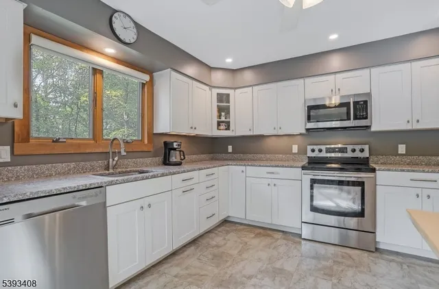 a kitchen with stainless steel appliances granite countertop a sink and a stove