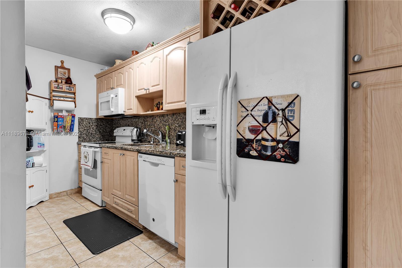 627 West 68th Street, Unit 627 Hialeah, FL 33014 - Photo 19 of 31 a kitchen with white cabinets and white appliances