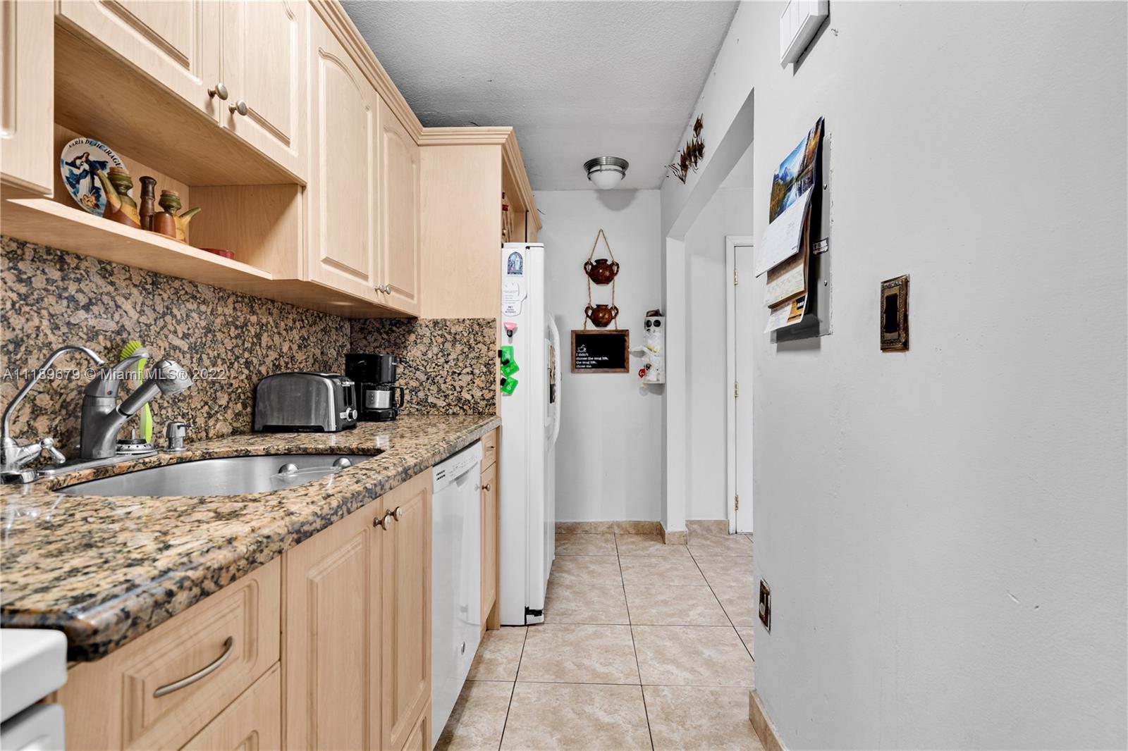 627 West 68th Street, Unit 627 Hialeah, FL 33014 - Photo 20 of 31 a kitchen with granite countertop a sink and a stove